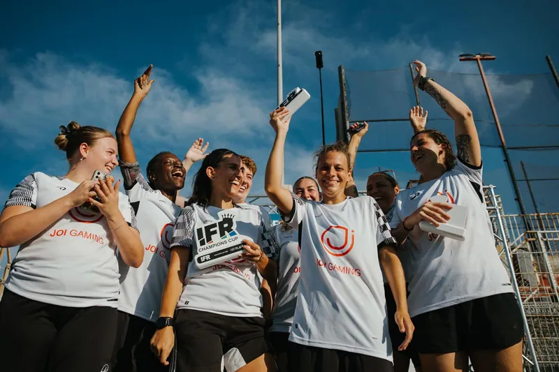 A women's team celebrates with their IFR Champions Cup trophy