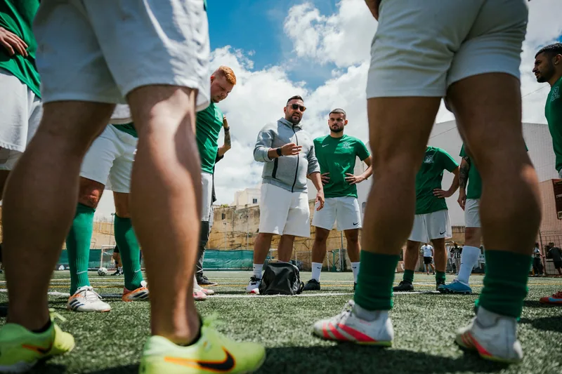 A team gathers around their coach before a Football League match