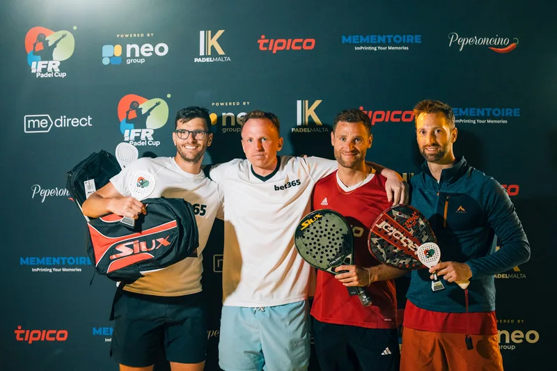 Four players with trophies and padel rackets at the awards presentation