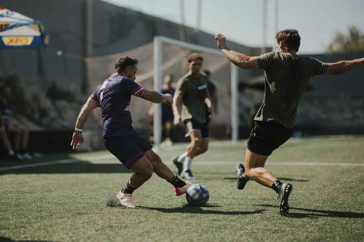 A Flutter Malta player in navy and pink challenges for the ball at the 2026 Champions Cup